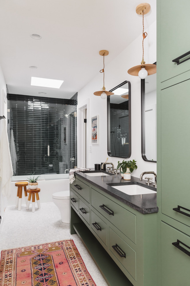 Medium sized classic family bathroom in Birmingham with flat-panel cabinets, a shower/bath combination, a one-piece toilet, blue tiles, cement tiles, white walls, marble flooring, a submerged sink, granite worktops, white floors, a hinged door, black worktops, a wall niche, double sinks and a freestanding vanity unit.