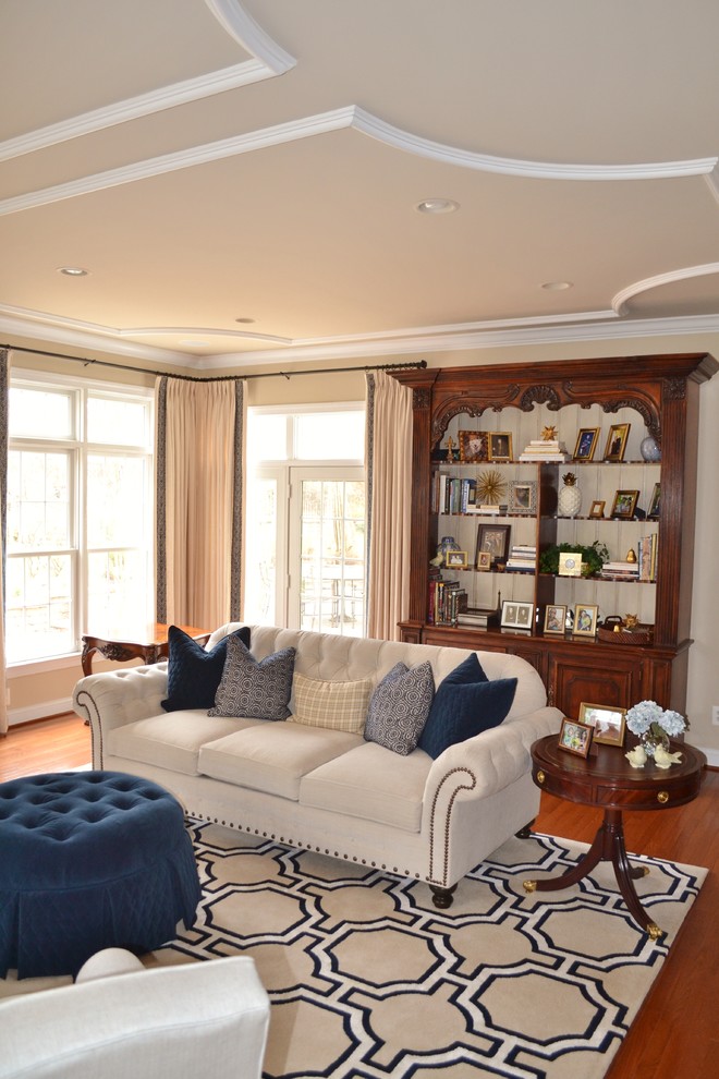 Design ideas for a traditional living room in Baltimore with a library, beige walls, medium hardwood floors, a standard fireplace, a brick fireplace surround and a concealed tv.