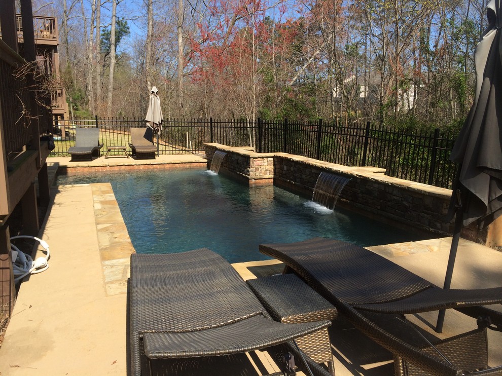 Photo of a small traditional backyard custom-shaped natural pool in Atlanta with a water feature and decking.