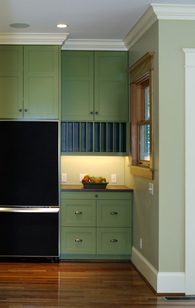 This is an example of a traditional kitchen in Seattle with green cabinets and black appliances.