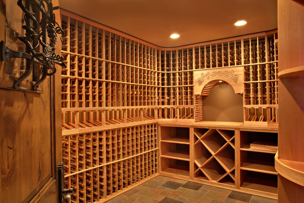 Photo of a mid-sized traditional wine cellar in Chicago with slate floors and display racks.
