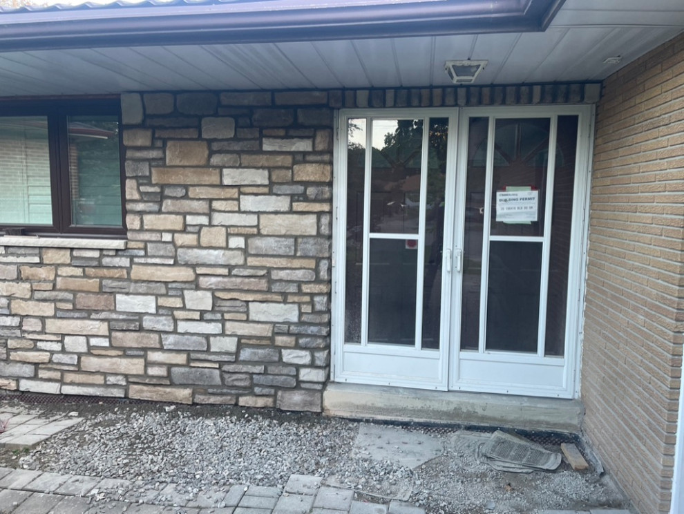 Photo of a traditional house exterior in Toronto with stone veneer.