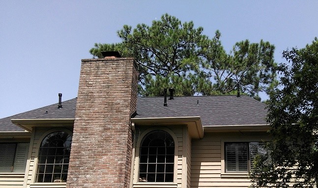 Example of a mid-sized classic beige two-story vinyl gable roof design in Houston with a shingle roof