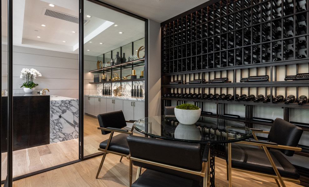 Mid-sized contemporary wine cellar in Los Angeles with light hardwood floors, display racks and beige floor.