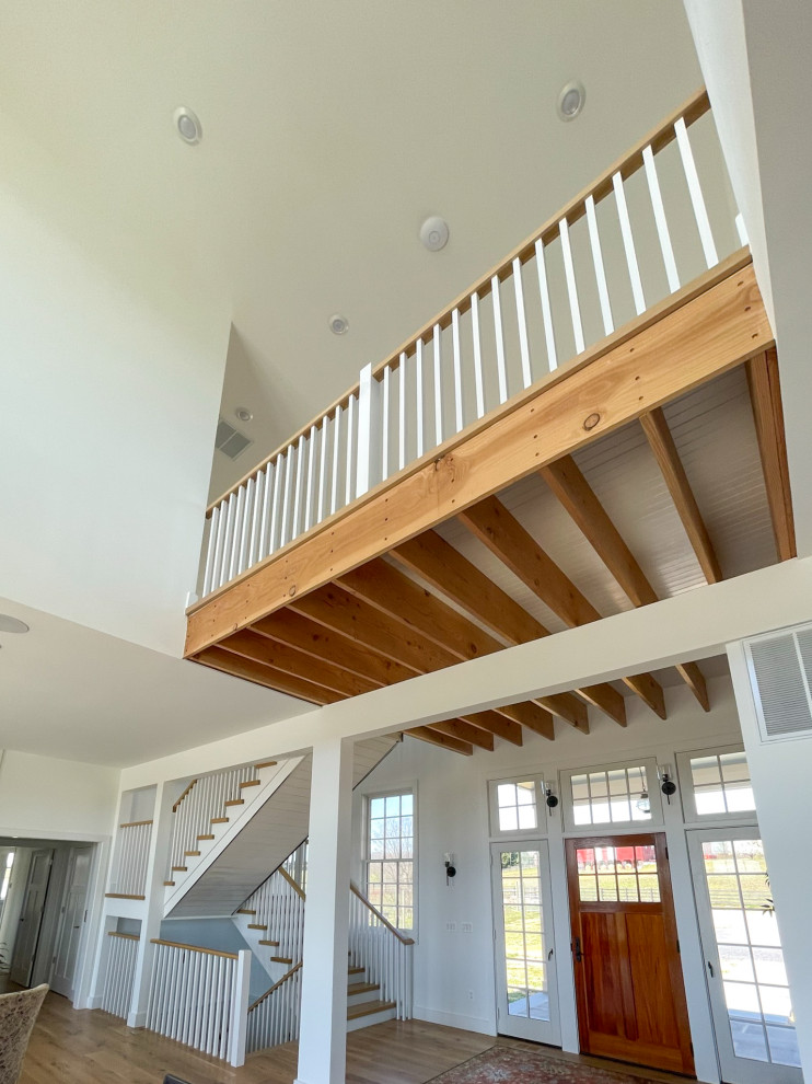 Modelo de escalera en U de estilo de casa de campo de tamaño medio con escalones de madera, contrahuellas de madera, barandilla de madera y machihembrado