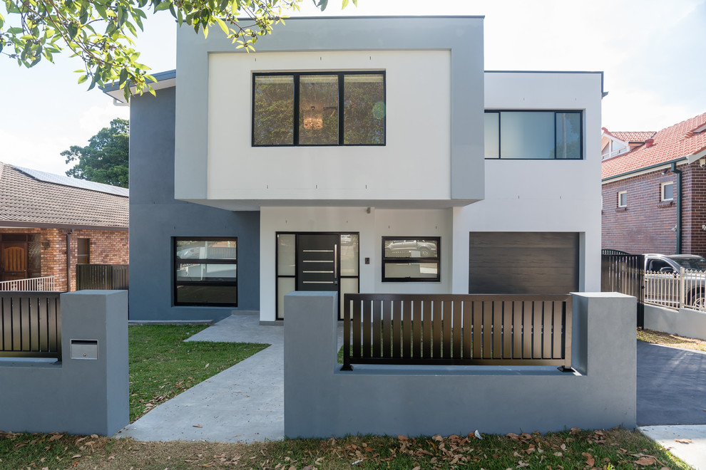 Inspiration for a contemporary two-storey stucco multi-coloured house exterior in Sydney with a flat roof.