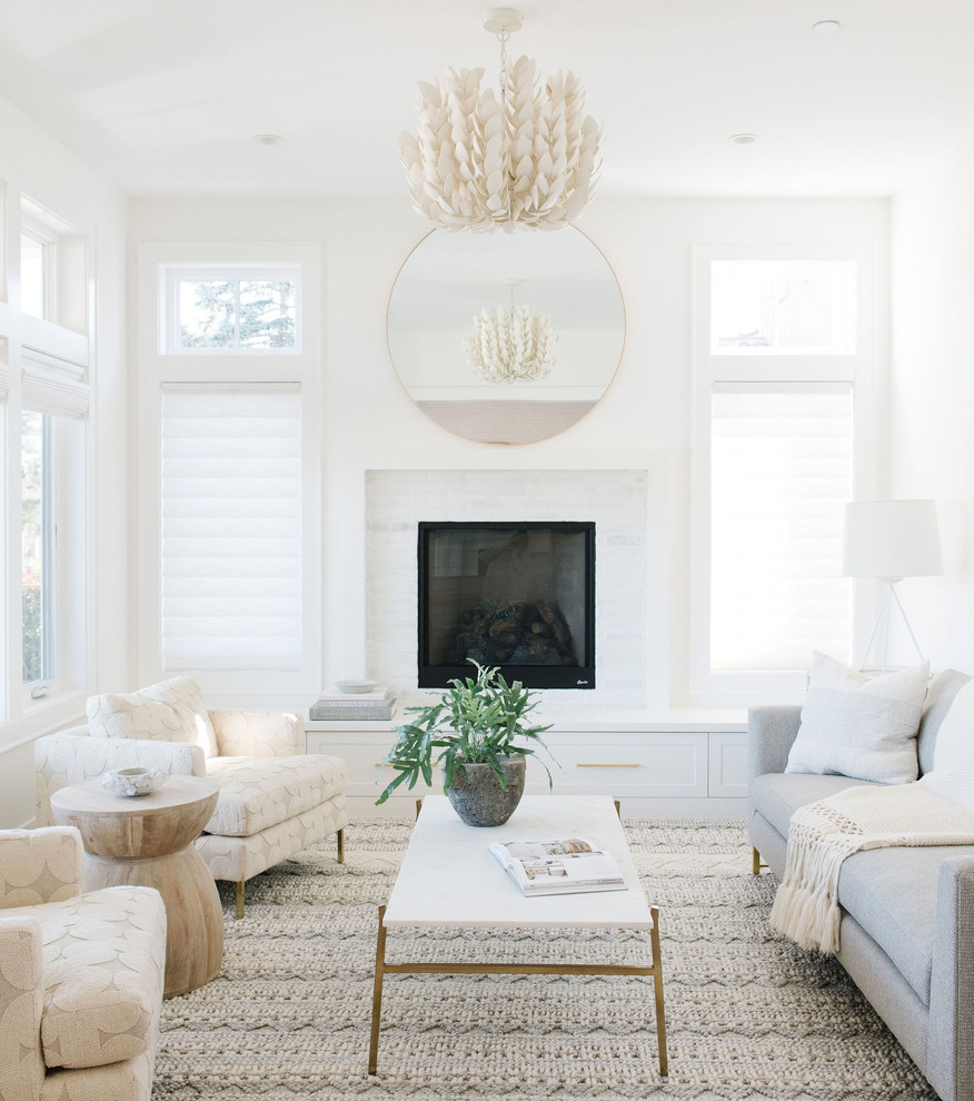 Inspiration for a beach style living room in San Francisco with white walls, a standard fireplace and white floor.