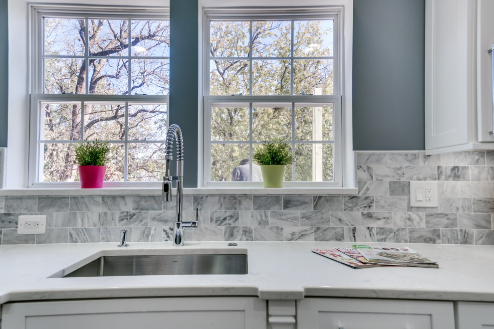 Photo of a large modern l-shaped eat-in kitchen in DC Metro with a drop-in sink, shaker cabinets, white cabinets, marble benchtops, grey splashback, mosaic tile splashback, stainless steel appliances, plywood floors, with island, grey floor and white benchtop.