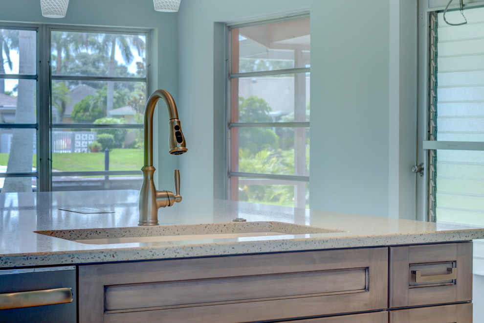 Large transitional l-shaped ceramic tile and gray floor home design photo with an undermount sink, shaker cabinets, white cabinets, recycled glass countertops, blue backsplash, glass tile backsplash, stainless steel appliances, an island and white countertops