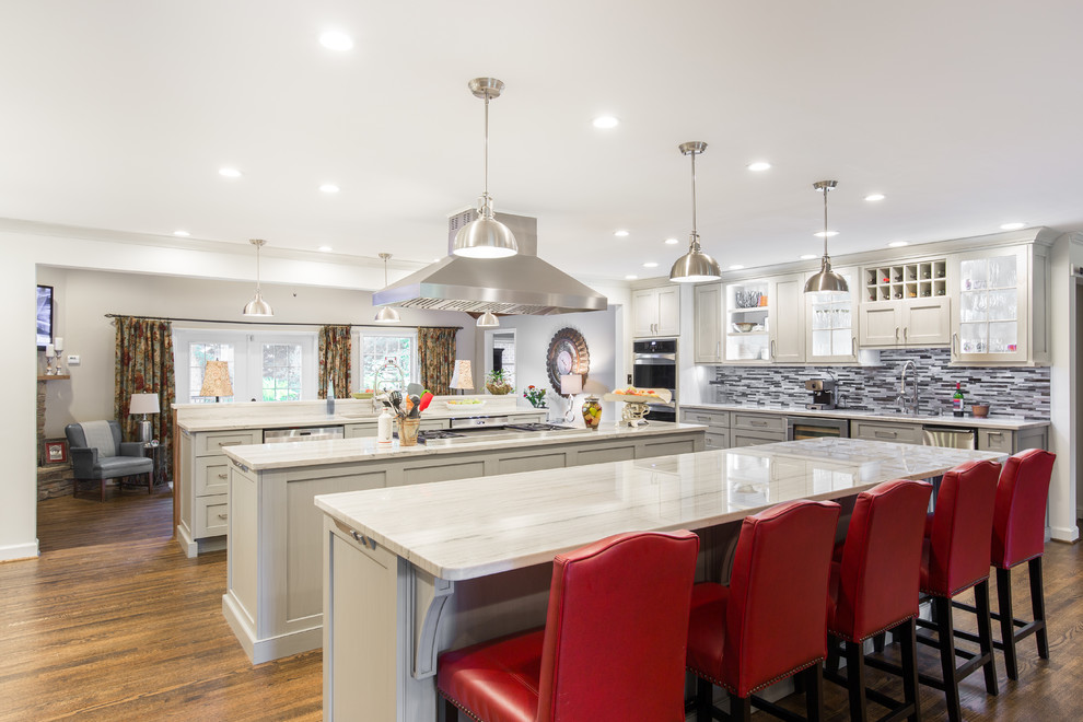 Eat-in kitchen - large transitional single-wall medium tone wood floor and brown floor eat-in kitchen idea with an undermount sink, shaker cabinets, white cabinets, marble countertops, multicolored backsplash, matchstick tile backsplash, stainless steel appliances and two islands