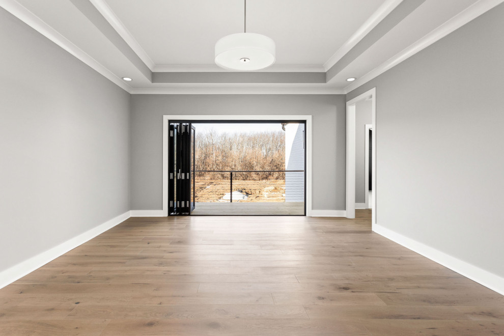 Mittelgroßes Modernes Hauptschlafzimmer mit grauer Wandfarbe, hellem Holzboden, buntem Boden und Kassettendecke in Indianapolis