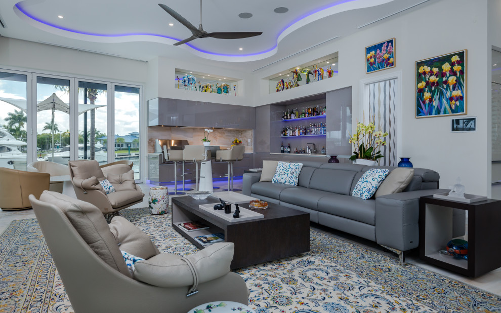Contemporary open concept living room in Tampa with a home bar, white walls, marble floors and recessed.