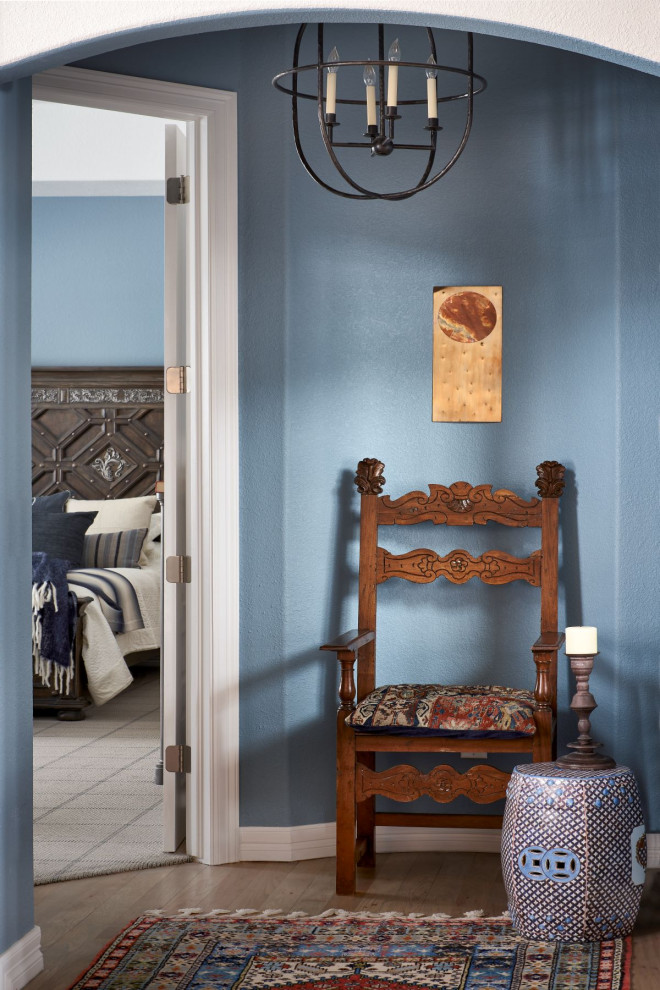 Exemple d'un couloir chic de taille moyenne avec un mur bleu, un sol en bois brun et un sol marron.