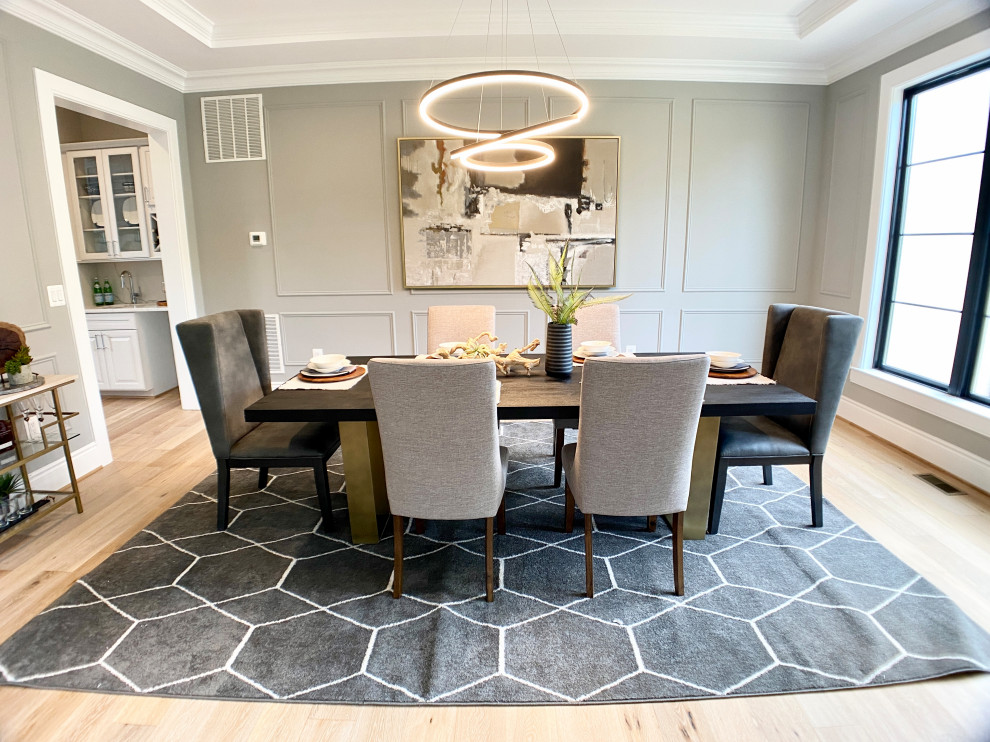 Photo of a large country separate dining room in DC Metro with grey walls, light hardwood floors, no fireplace, beige floor and recessed.