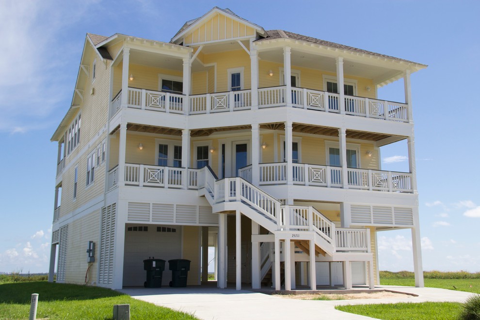 Inspiration for a large beach style three-storey yellow exterior in Houston with concrete fiberboard siding and a gable roof.