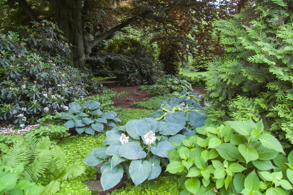 This is an example of a mid-sized traditional shade side yard stone landscaping in Boston.
