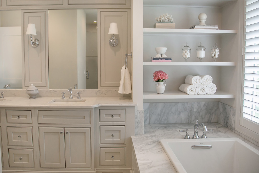 This is an example of a mid-sized transitional master bathroom in Milwaukee with beaded inset cabinets, grey cabinets, a drop-in tub, an alcove shower, a two-piece toilet, white tile, marble, grey walls, marble floors, an undermount sink, engineered quartz benchtops, white floor, a hinged shower door and white benchtops.