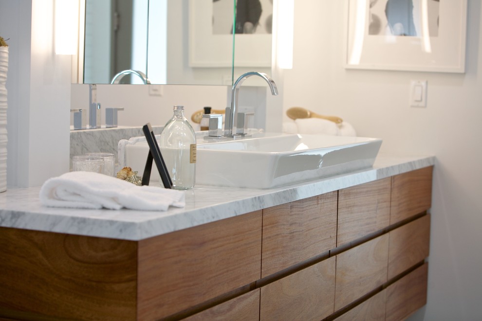 Large beach style master bathroom in Los Angeles with flat-panel cabinets, medium wood cabinets, white walls, porcelain floors, a vessel sink, marble benchtops, brown floor, grey benchtops, a double vanity and a floating vanity.