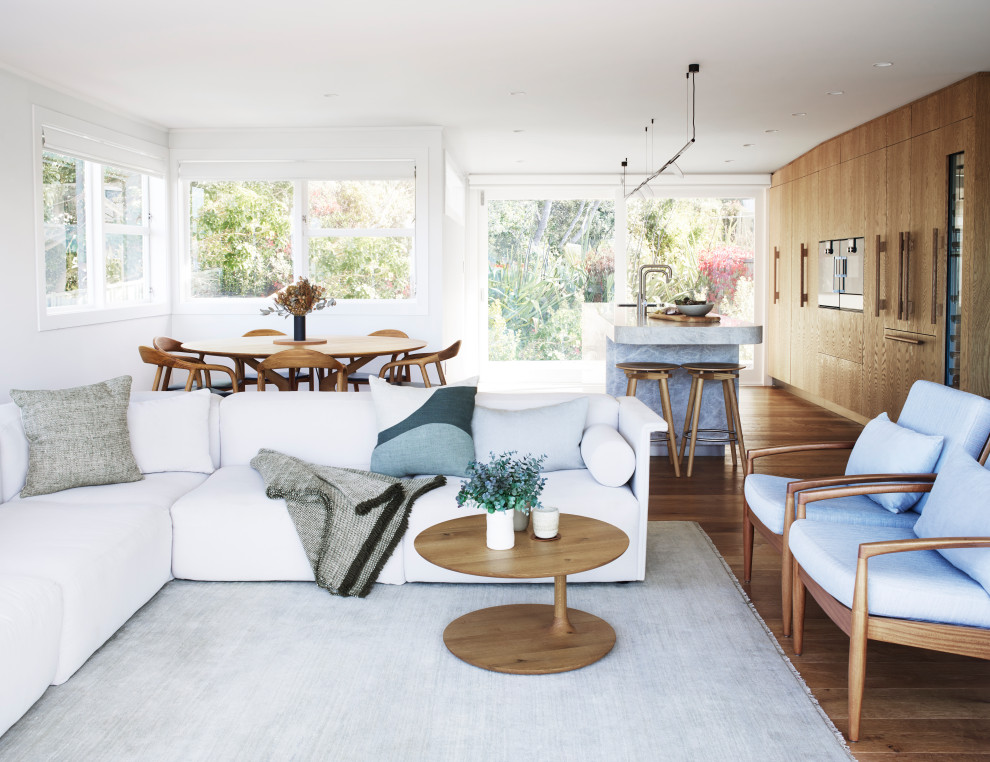 Small midcentury open plan living room in Auckland with a home bar, white walls, medium hardwood flooring, no fireplace, a wall mounted tv, turquoise floors, all types of ceiling and all types of wall treatment.