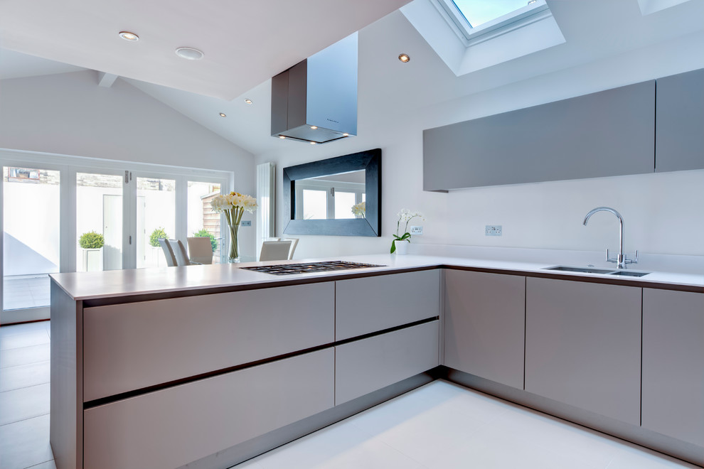 Photo of a large modern l-shaped open plan kitchen in Other with a drop-in sink, flat-panel cabinets, stainless steel cabinets, granite benchtops, white splashback, stone slab splashback, stainless steel appliances, ceramic floors and no island.