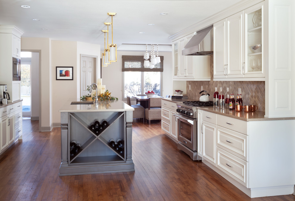Inspiration for a mid-sized transitional u-shaped eat-in kitchen in Denver with louvered cabinets, white cabinets, beige splashback, porcelain splashback, stainless steel appliances, medium hardwood floors, with island, brown floor and beige benchtop.