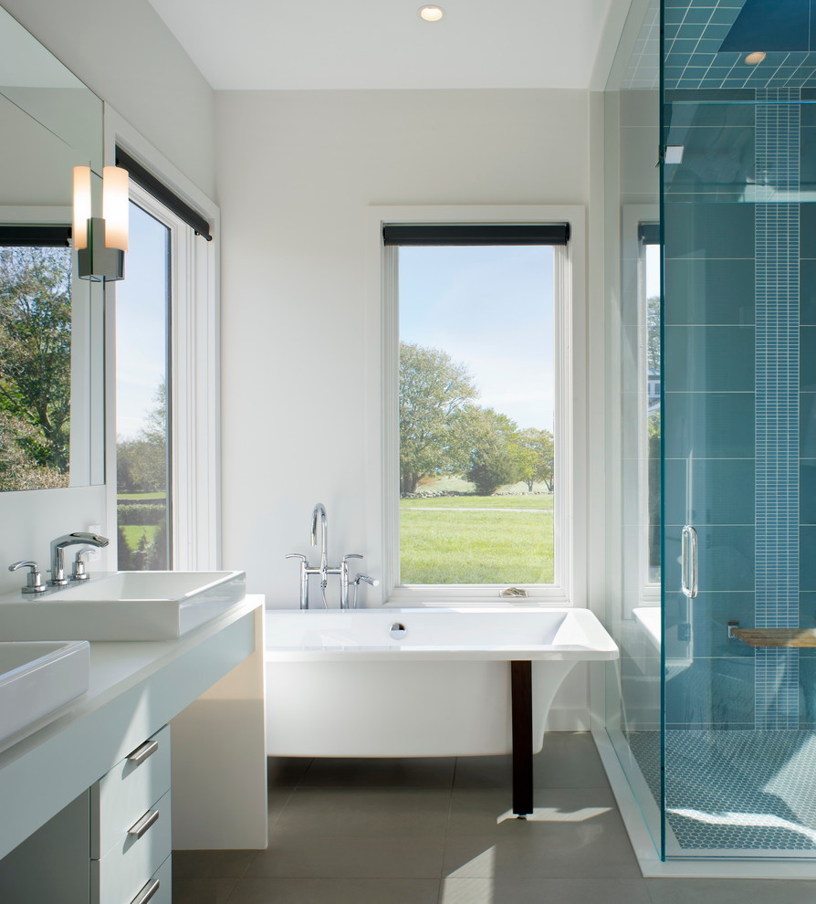 Design ideas for a contemporary bathroom in Providence with a vessel sink, flat-panel cabinets, white cabinets, a freestanding tub, a corner shower, blue tile and white walls.