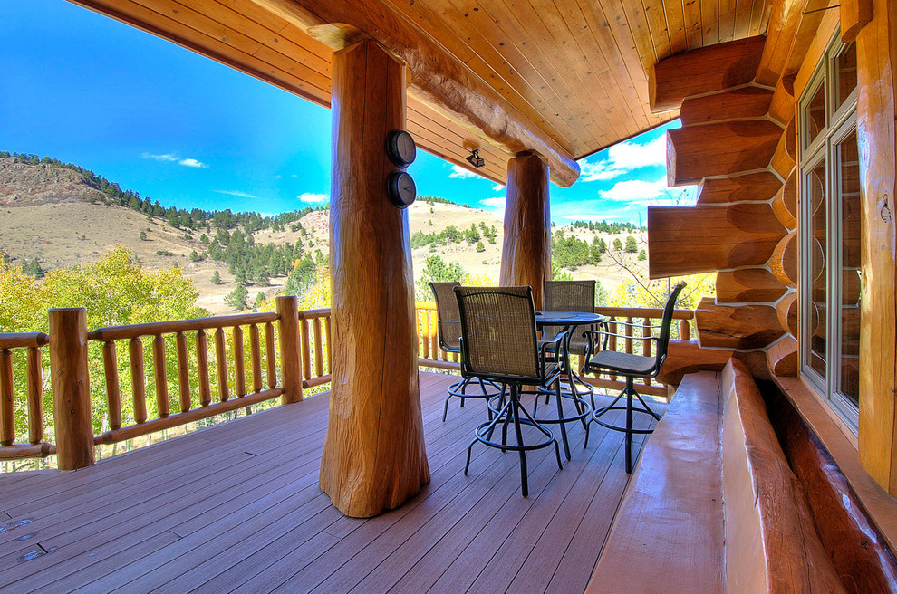 Inspiration for a large rustic backyard deck remodel in Denver with a roof extension