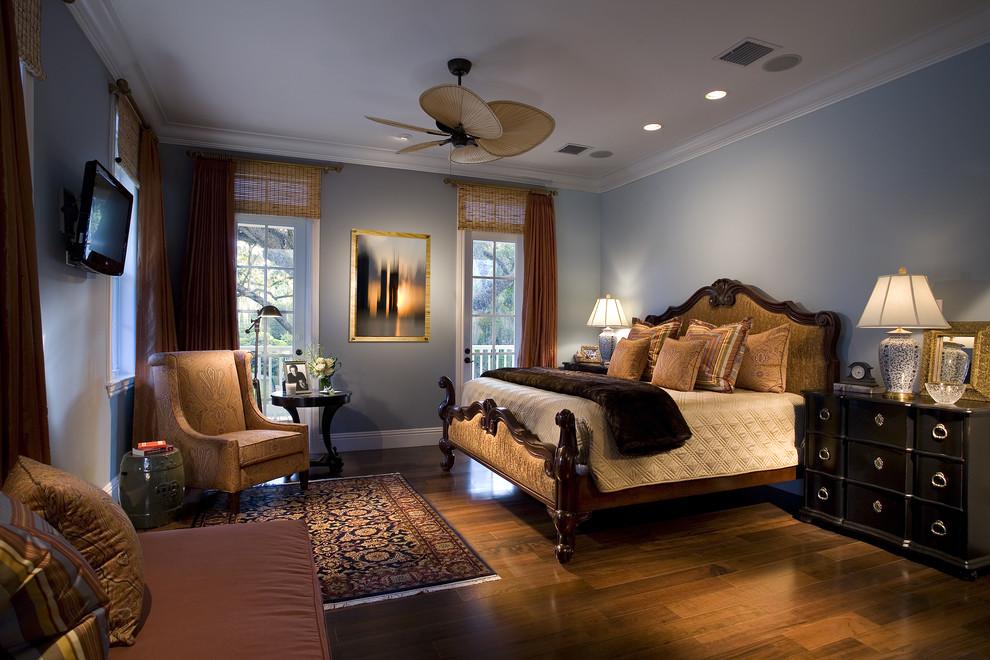 Traditional bedroom in Miami with blue walls and dark hardwood floors.