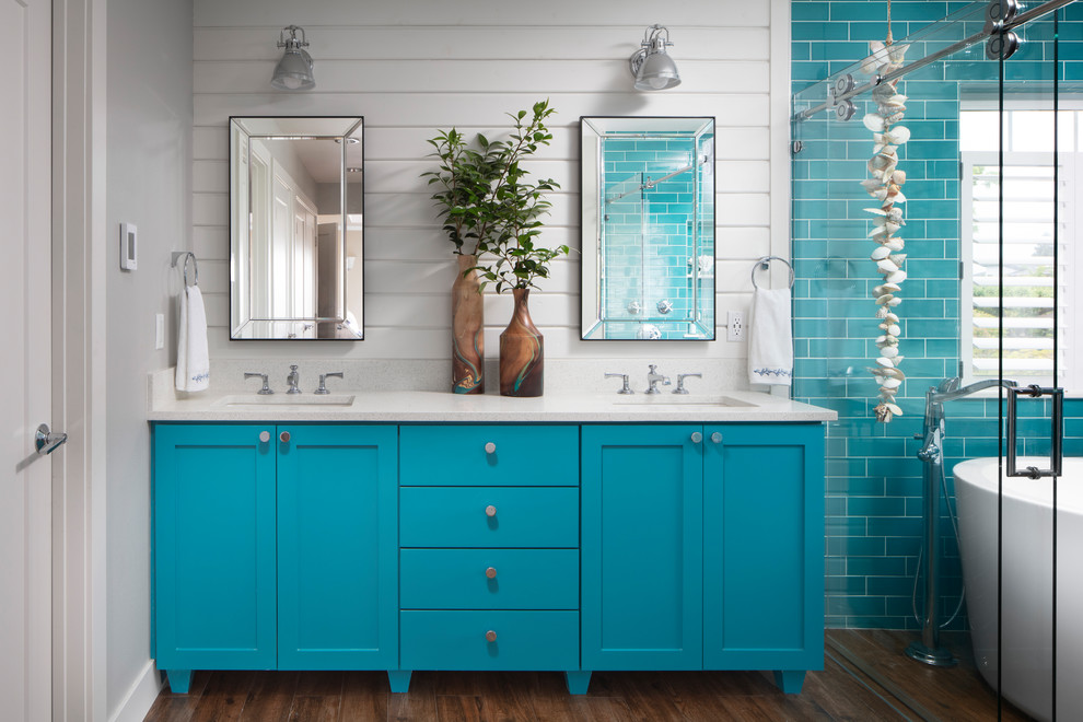 Design ideas for a beach style master wet room bathroom in Seattle with shaker cabinets, turquoise cabinets, a freestanding tub, blue tile, subway tile, white walls, dark hardwood floors, an undermount sink, brown floor, white benchtops and a sliding shower screen.