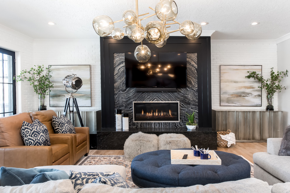 Inspiration for a mid-sized transitional enclosed family room in Salt Lake City with a home bar, white walls, light hardwood floors, a ribbon fireplace, a stone fireplace surround, a wall-mounted tv and brown floor.