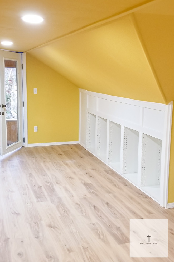 Großes, Repräsentatives, Abgetrenntes Modernes Wohnzimmer mit gelber Wandfarbe, Laminat, braunem Boden und gewölbter Decke in Seattle