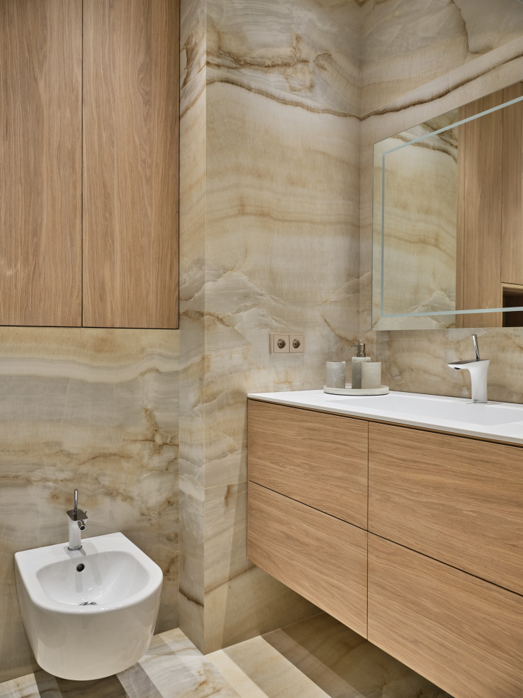 Small contemporary ensuite bathroom in Moscow with flat-panel cabinets, light wood cabinets, an alcove bath, a wall mounted toilet, beige tiles, porcelain tiles, beige walls, porcelain flooring, a submerged sink, engineered stone worktops, beige floors, a sliding door, white worktops, a single sink and a floating vanity unit.