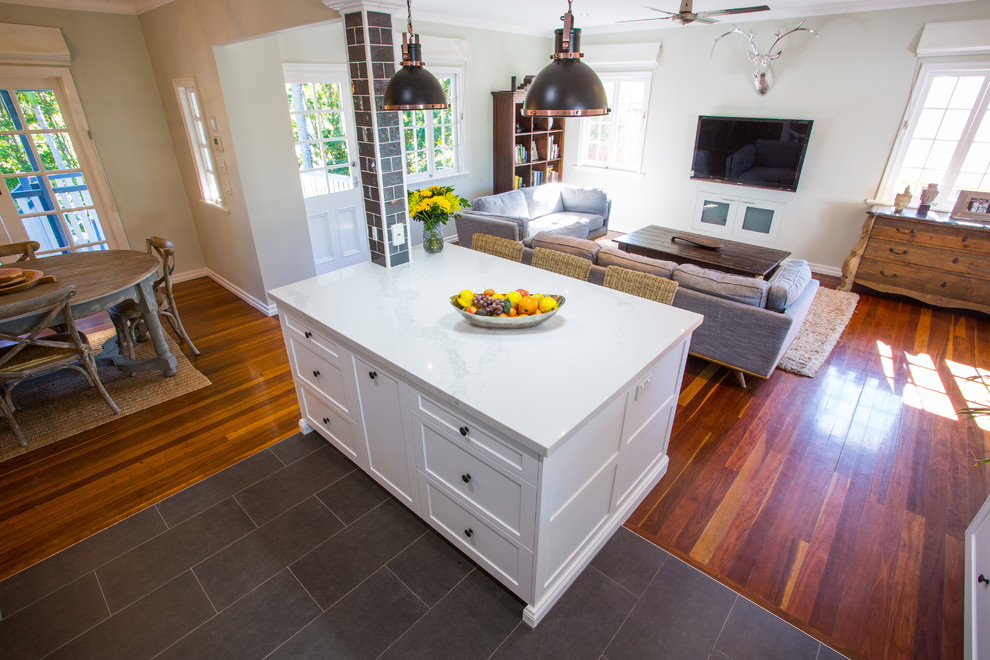 Inspiration for a large traditional l-shaped open plan kitchen in Brisbane with an undermount sink, shaker cabinets, white cabinets, quartz benchtops, grey splashback, subway tile splashback, black appliances, ceramic floors, with island and grey floor.