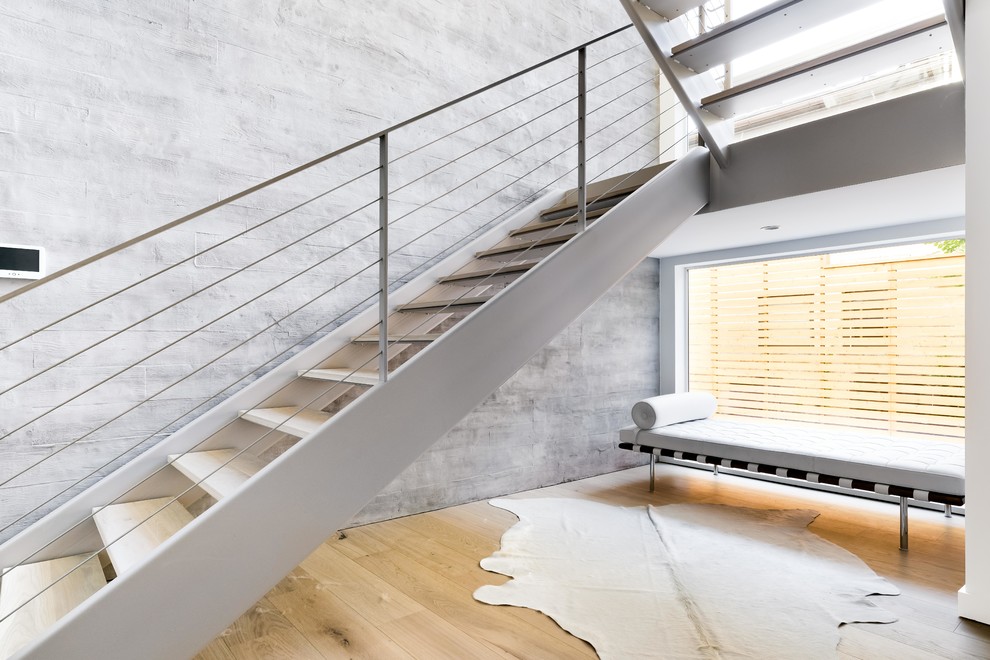 Contemporary wood u-shaped staircase in Dallas with open risers and metal railing.