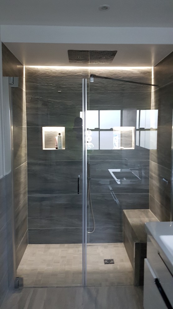 Design ideas for a contemporary master bathroom in Dublin with a shower/bathtub combo, gray tile, porcelain tile, beige floor and a hinged shower door.