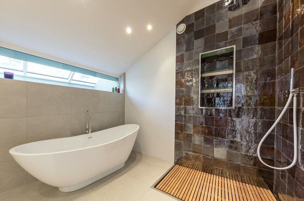 Photo of a mid-sized contemporary 3/4 bathroom in Oxfordshire with an open shower, an open shower, flat-panel cabinets, brown cabinets, a freestanding tub, a one-piece toilet, brown tile, glass sheet wall, white walls, cement tiles, a drop-in sink, tile benchtops and white floor.