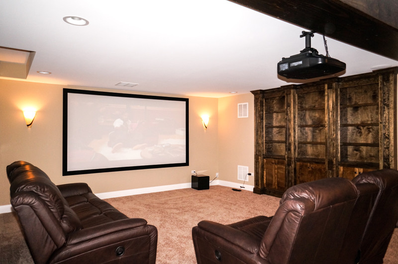 Large country home theatre in Chicago with beige walls.