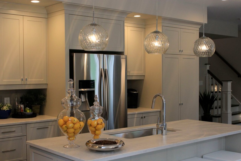 Eat-in kitchen - large transitional l-shaped dark wood floor eat-in kitchen idea with an undermount sink, shaker cabinets, white cabinets, marble countertops, stainless steel appliances, an island, gray backsplash and ceramic backsplash