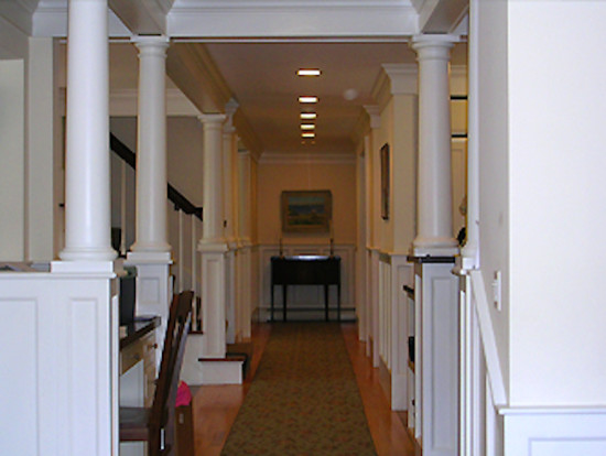 Inspiration for a mid-sized transitional light wood floor hallway remodel in Boston with white walls