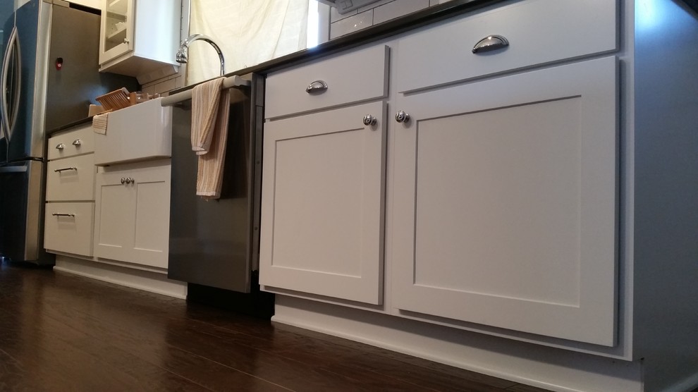 Inspiration for a transitional galley dark wood floor eat-in kitchen remodel with white cabinets, granite countertops, white backsplash, subway tile backsplash and stainless steel appliances