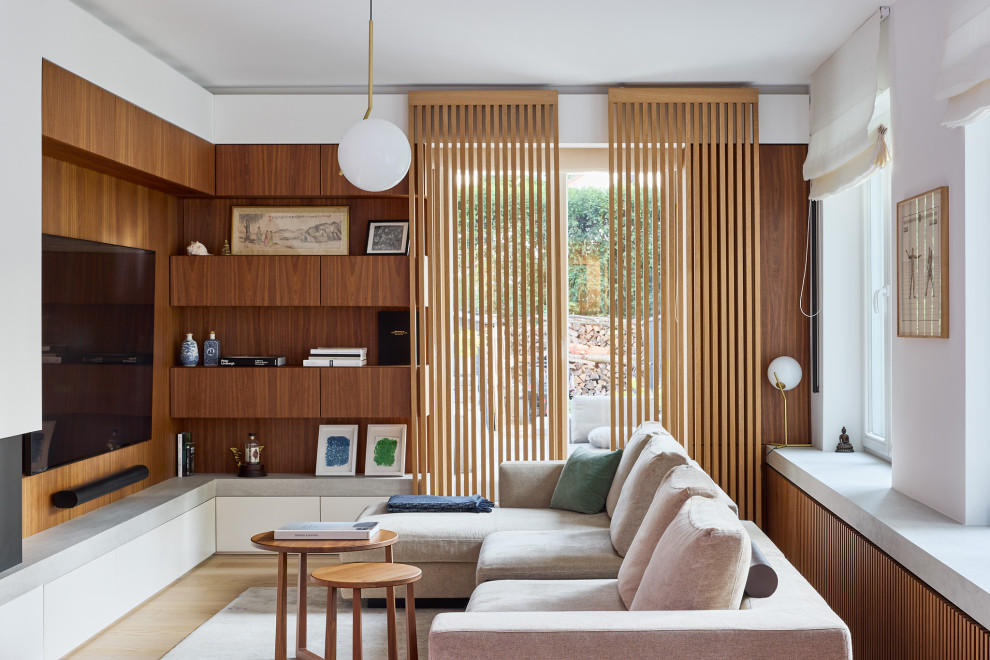 Immagine di un ampio soggiorno minimal aperto con sala formale, camino ad angolo, cornice del camino in pietra, TV a parete e pareti in legno