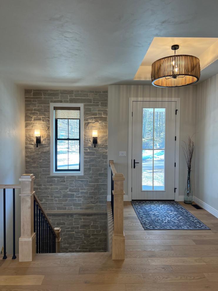 Foyer - large transitional medium tone wood floor, brown floor and tray ceiling foyer idea with white walls and a white front door