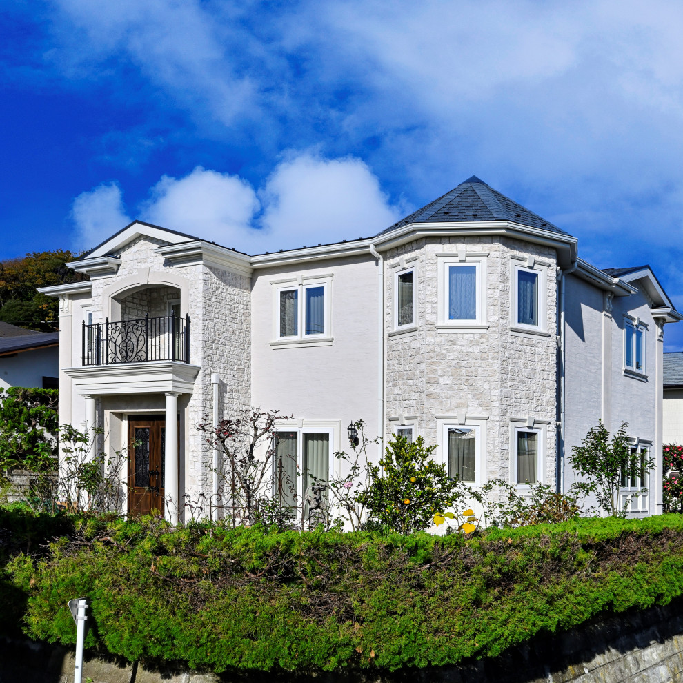 Foto de fachada de casa blanca y azul clásica grande de dos plantas con revestimiento de estuco, tejado a cuatro aguas y tejado de varios materiales