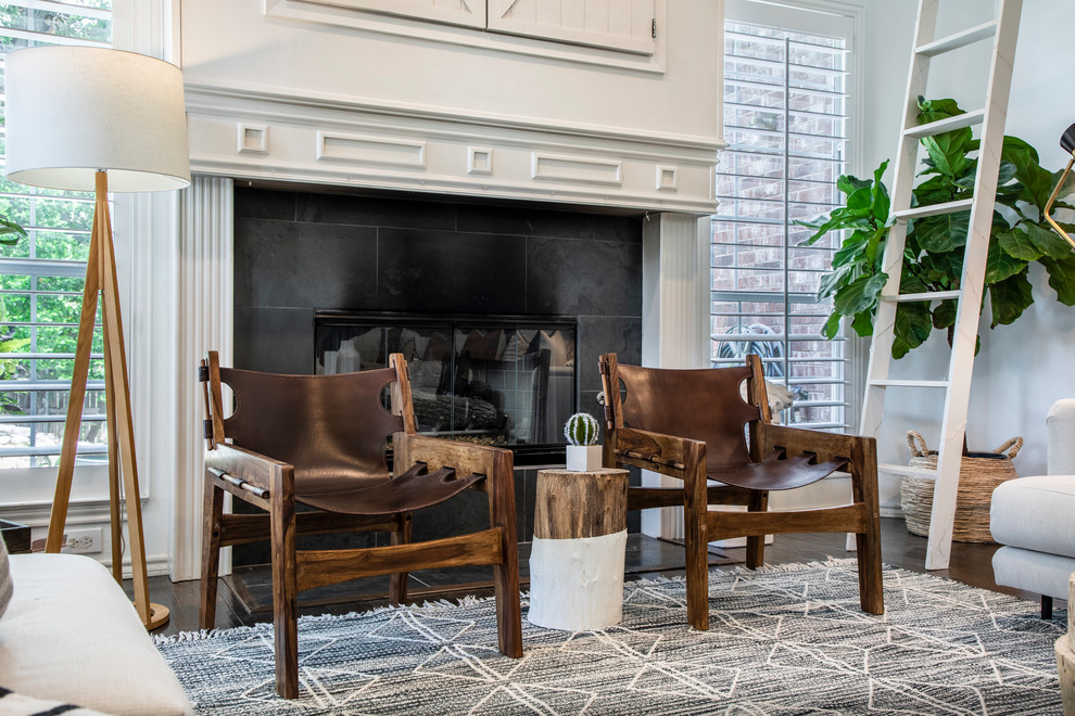 Photo of a large beach style open concept living room in Dallas with white walls, dark hardwood floors, a standard fireplace, a wood fireplace surround, a concealed tv and brown floor.
