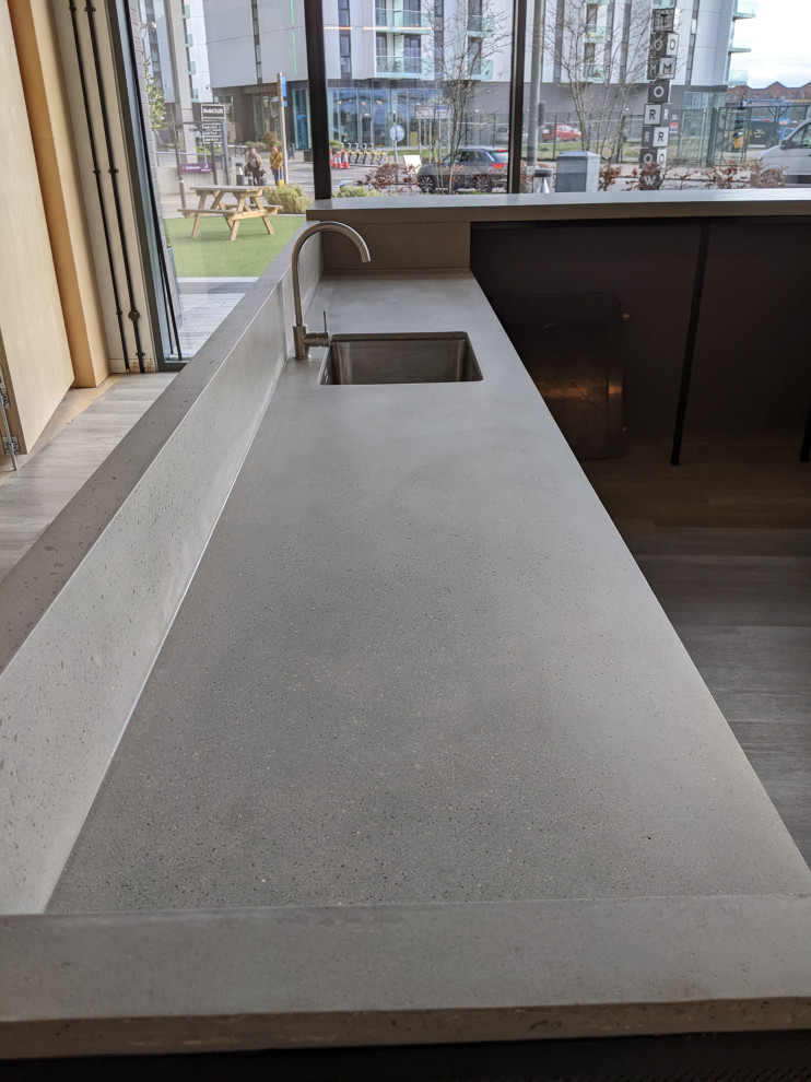 Inspiration for a large industrial u-shaped kitchen in Manchester with a submerged sink, concrete worktops, grey splashback, cement tile splashback, stainless steel appliances, no island and grey worktops.