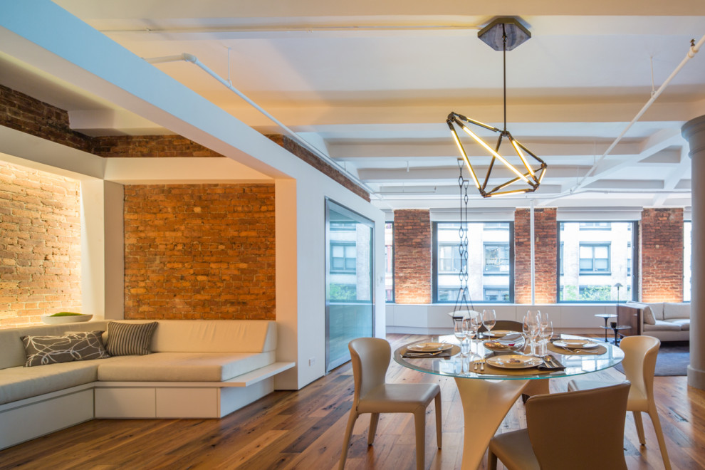 Idee per una sala da pranzo aperta verso la cucina industriale di medie dimensioni con pareti bianche, pavimento in legno massello medio, pavimento marrone, travi a vista e pareti in mattoni
