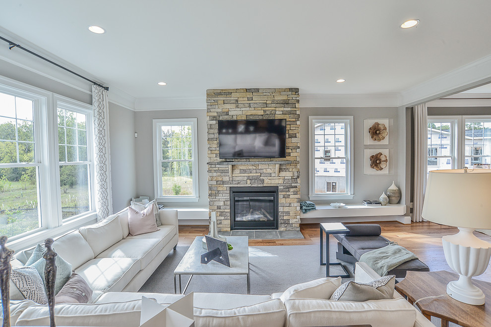 Design ideas for a large transitional open concept family room in DC Metro with grey walls, medium hardwood floors, a standard fireplace, a stone fireplace surround and a wall-mounted tv.