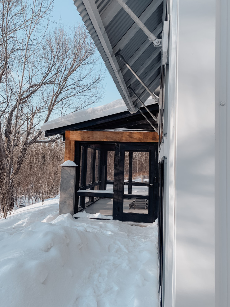 Diseño de fachada de casa blanca campestre pequeña de dos plantas con revestimiento de metal, tejado a dos aguas, tejado de metal y panel y listón