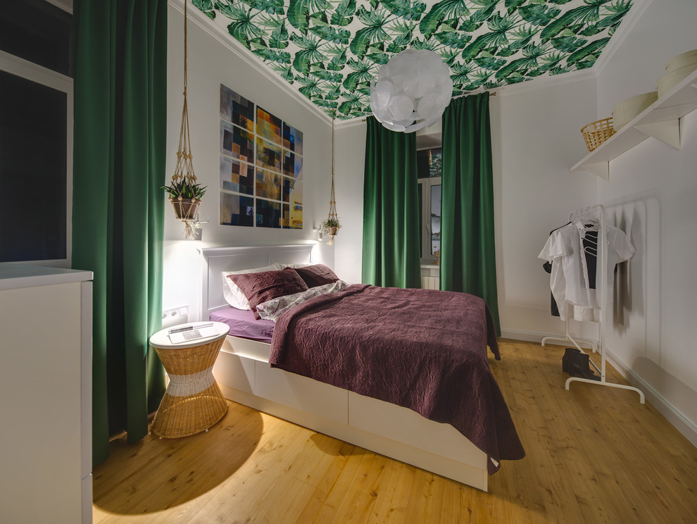 Scandinavian master bedroom in Other with white walls and medium hardwood floors.