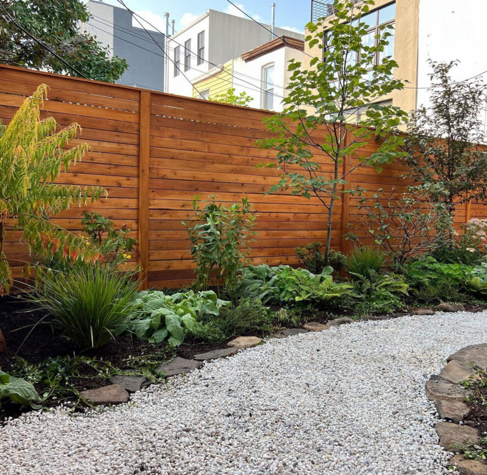 Пример оригинального дизайна: маленький засухоустойчивый сад на заднем дворе в современном стиле с садовой дорожкой или калиткой, покрытием из гравия и с деревянным забором для на участке и в саду